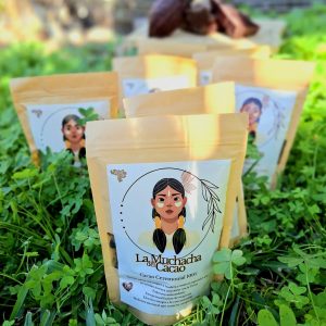 Bolsas de cacao ceremonial 100% puro de La Muchacha del Cacao sobre hierba verde.