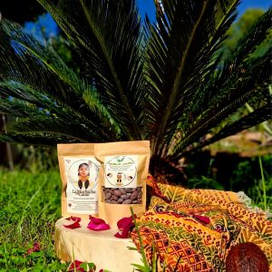 Pack de cacao ceremonial 100% y semillas de cacao de La Muchacha del Cacao sobre una manta con pétalos, en un entorno natural.