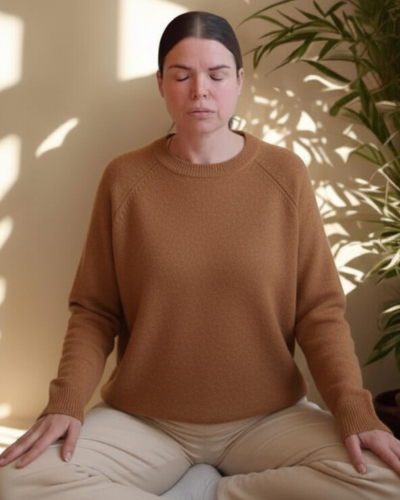 Mujer meditando con ojos cerrados en espacio luminoso, práctica de regulación del sistema nervioso en programa de 21 días con cacao.